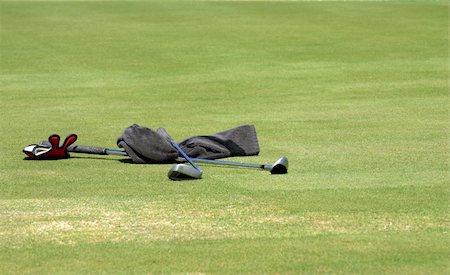 simsearch:400-04942642,k - Wet towel and two golf clubs lying on the green grass at the golf course. Sunny day. Photographie de stock - Aubaine LD & Abonnement, Code: 400-04433547