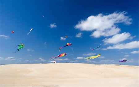 deltaplano - Multicolor kites flying over sandy hill in bright sunny afternoon Fotografie stock - Microstock e Abbonamento, Codice: 400-04444453