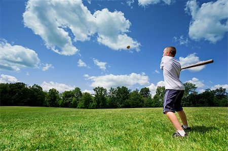 Young Caucasian boy playing baseball in a sunny field on a beautiful summer day. Foto de stock - Royalty-Free Super Valor e Assinatura, Número: 400-04444481