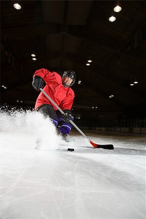 Caucasian woman hockey player sliding kicking up ice. Stock Photo - Budget Royalty-Free & Subscription, Code: 400-04445108