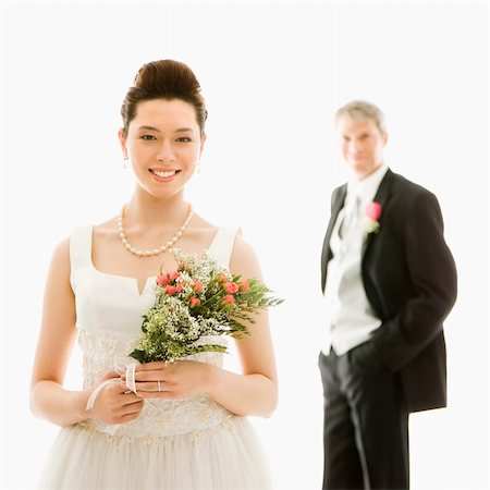 simsearch:400-04950359,k - Portrait of Asian bride in foreground and Caucasian groom in background. Stock Photo - Budget Royalty-Free & Subscription, Code: 400-04445226