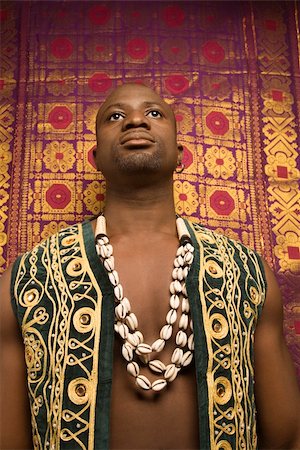 embroidery for male clothes - Low angle portrait of African-American mid-adult man wearing embroidered African vest and beads. Stock Photo - Budget Royalty-Free & Subscription, Code: 400-04445423