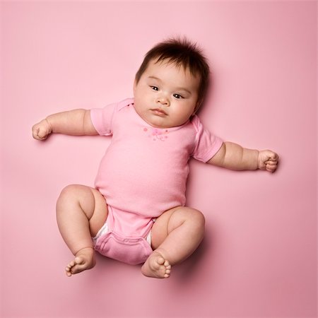 Asian baby lying on back lookin up at viewer with arms out to side. Stock Photo - Budget Royalty-Free & Subscription, Code: 400-04445749