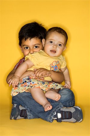 sister hugs baby - Hispanic and African American male child in cowboy hats shaking hands. Stock Photo - Budget Royalty-Free & Subscription, Code: 400-04445786