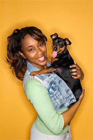simsearch:400-04446187,k - African American young adult female holding Miniature Pinscher dog. Photographie de stock - Aubaine LD & Abonnement, Code: 400-04446219