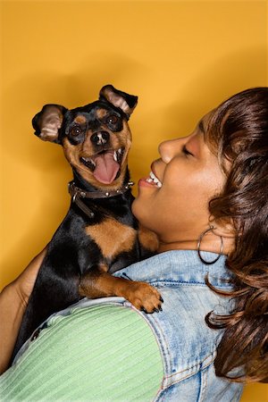 simsearch:400-04446187,k - African American young adult female holding Miniature Pinscher dog. Photographie de stock - Aubaine LD & Abonnement, Code: 400-04446220