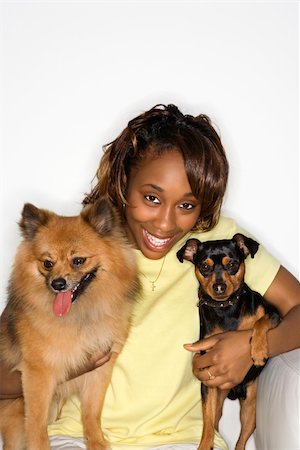 simsearch:400-04446187,k - African American young adult female holding brown Pomeranian and Miniature Pinscher dogs. Photographie de stock - Aubaine LD & Abonnement, Code: 400-04446223