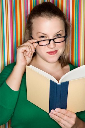 simsearch:400-03923096,k - Young Caucasian female adult reading and looking at viewer over glasses. Stock Photo - Budget Royalty-Free & Subscription, Code: 400-04446335