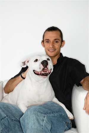 simsearch:400-04446187,k - Young adult male Caucasian holding white Pit Bull dog on lap. Photographie de stock - Aubaine LD & Abonnement, Code: 400-04446373