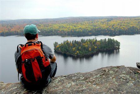 A hiker sitting on a cliff edge enjoying scenic view Stock Photo - Budget Royalty-Free & Subscription, Code: 400-04446965