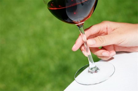 Red wine in glass with female hand and nice green background Stock Photo - Budget Royalty-Free & Subscription, Code: 400-04447603