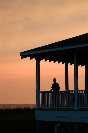 simsearch:400-03923118,k - Boy on beachfront porch silhouetted at sunset Fotografie stock - Microstock e Abbonamento, Codice: 400-04448488