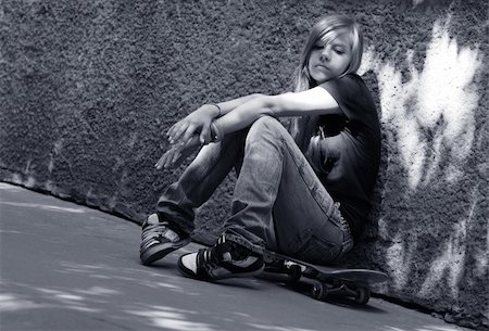 depressed woman in the street - The girl with skateboard sitting against a wall. Shadow on a wall as a wing Stock Photo - Budget Royalty-Free & Subscription, Code: 400-04448707
