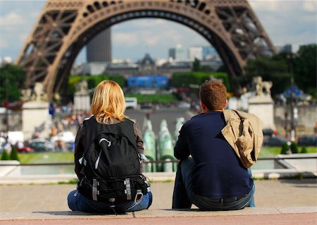 simsearch:400-04955587,k - Young tourist couple sitting in front of Eiffel tower in Paris France Fotografie stock - Microstock e Abbonamento, Codice: 400-04448773