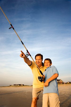 simsearch:400-04953081,k - Caucasian mid-adult man shore fishing on beach with pre-teen boy and pointing. Foto de stock - Royalty-Free Super Valor e Assinatura, Número: 400-04448888