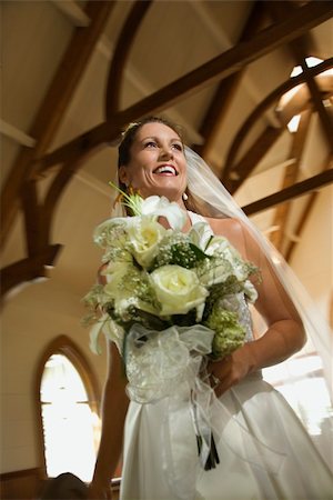simsearch:400-04950359,k - Portrait of mid-adult bride holding bouquet leaving a church. Stock Photo - Budget Royalty-Free & Subscription, Code: 400-04449068