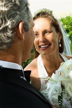 simsearch:400-04950359,k - Looking over groom's shoulder at smiling bride. Stock Photo - Budget Royalty-Free & Subscription, Code: 400-04449071