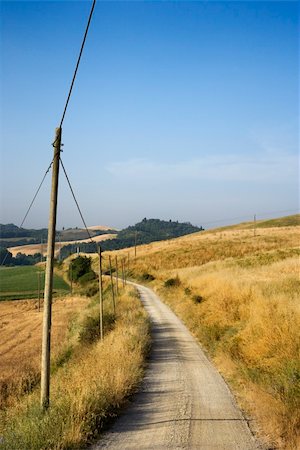 simsearch:400-03923721,k - Telephone poles beside dirt road leading through rolling hills in countryside of Tuscany, Italy. Stock Photo - Budget Royalty-Free & Subscription, Code: 400-04449444
