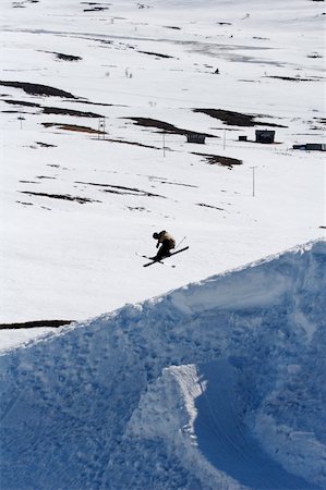 salto - A freestyle skier doing a 180 over a backcountry jump. Stockbilder - Microstock & Abonnement, Bildnummer: 400-04440875