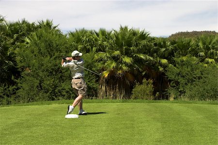 simsearch:400-03997921,k - Golfer finishing the shot on the tee box. Golf club is still in motion. Stock Photo - Budget Royalty-Free & Subscription, Code: 400-04442900