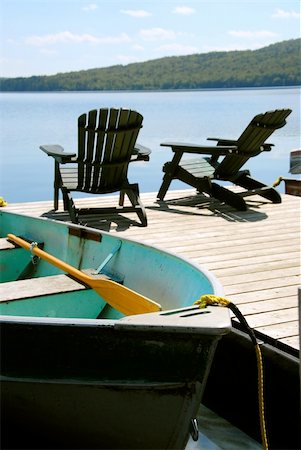 simsearch:862-06542036,k - Paddle boat and two adirondack wooden chairs on dock facing a blue lake Photographie de stock - Aubaine LD & Abonnement, Code: 400-04443975