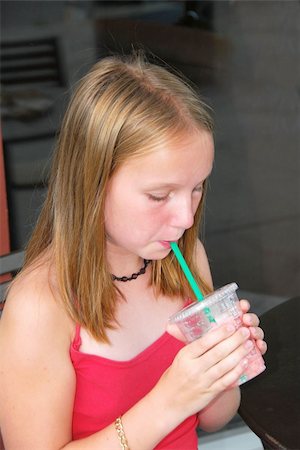 fruit milkshake in plastic cup - Young girl sitting in outside cafe and drinking a cool refreshing beverage Stock Photo - Budget Royalty-Free & Subscription, Code: 400-04454690