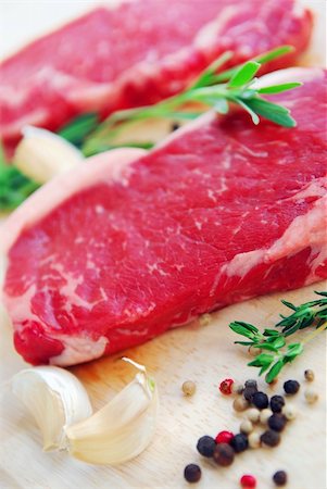 short loin - Two raw new york steaks on cutting board with thyme peppercorns and garlic Stock Photo - Budget Royalty-Free & Subscription, Code: 400-04454715