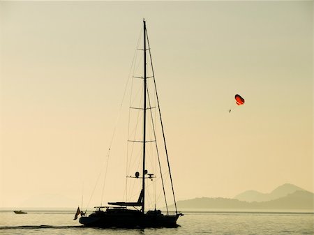 parachute, beach - Paragliding near Dubrovnik coast at sunset. Sailing boat passing by. Stock Photo - Budget Royalty-Free & Subscription, Code: 400-04455266