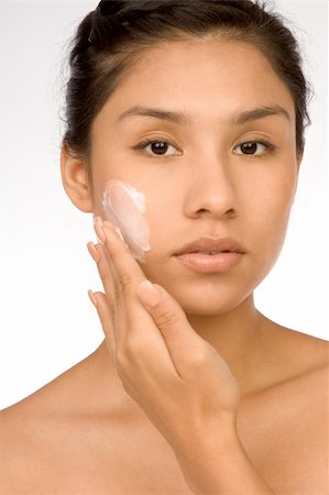 simsearch:400-04076979,k - Hispanic girl applying facial skincare product Photographie de stock - Aubaine LD & Abonnement, Code: 400-04455635