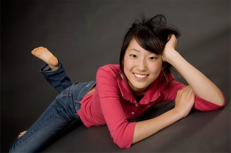 simsearch:400-04960190,k - Portrait of a beautiful Asian teenager posing on a gray background Photographie de stock - Aubaine LD & Abonnement, Code: 400-04456338
