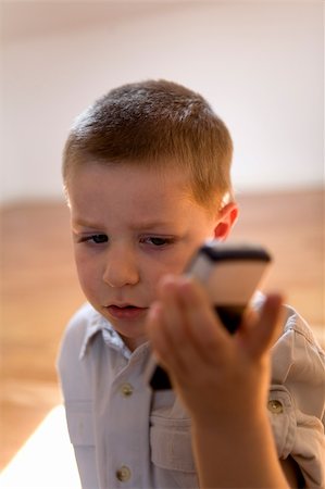 fabthi (artist) - Young cute little boy holding a mobile phone at home Stock Photo - Budget Royalty-Free & Subscription, Code: 400-04457084