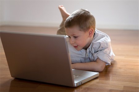 fabthi (artist) - Child lying down on the floor using a computer Stock Photo - Budget Royalty-Free & Subscription, Code: 400-04457080