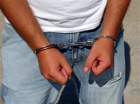 simsearch:400-06868559,k - Hands of the man - the criminal, chained in handcuffs Fotografie stock - Microstock e Abbonamento, Codice: 400-04457357