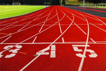 Lanes of a red race track with numbers and green football field Stock Photo - Budget Royalty-Free & Subscription, Code: 400-04458671