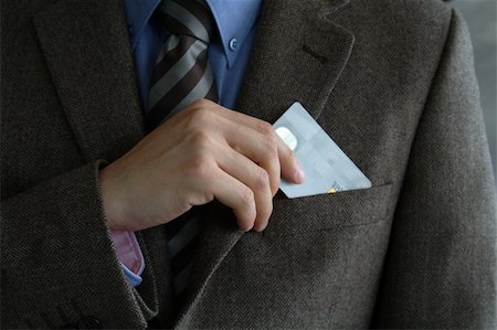 Smartly dressed business man putting a credit card into his pocket. Stock Photo - Budget Royalty-Free & Subscription, Code: 400-04459253