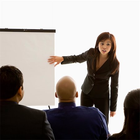 espetáculo amador - Vietnamese mid-adult woman standing in front of business group pointing to presentation. Foto de stock - Royalty-Free Super Valor e Assinatura, Número: 400-04450041