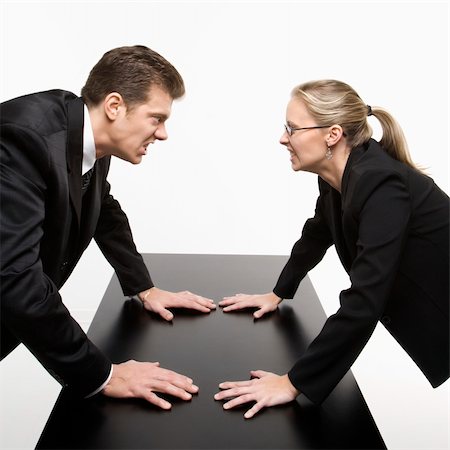 Caucasian mid-adult businessman and woman staring at each other with hostile expressions. Stock Photo - Budget Royalty-Free & Subscription, Code: 400-04450051