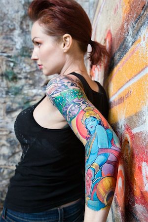 simsearch:400-04186416,k - Sexy tattooed Caucasian woman leaning on wall covered in graffiti. Stockbilder - Microstock & Abonnement, Bildnummer: 400-04450836