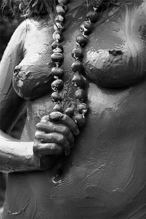 simsearch:400-03925003,k - Young adult Caucasian female nude covered in mud holding necklace. Fotografie stock - Microstock e Abbonamento, Codice: 400-04450958