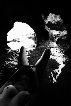 simsearch:400-04955255,k - Young nude Caucasian female lying down in a cave with water and covering groin with hands. Stockbilder - Microstock & Abonnement, Bildnummer: 400-04451052