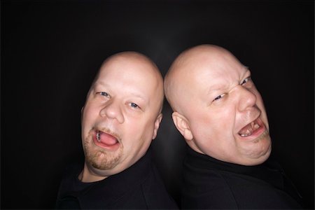 sibling sad - Caucasian bald mid adult identical twin  men standing back to back with sad expressions looking at viewer. Stock Photo - Budget Royalty-Free & Subscription, Code: 400-04451215