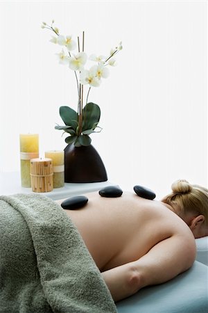 simsearch:400-04956215,k - Caucasian middle-aged woman lying on massage table with hot stones on her back. Photographie de stock - Aubaine LD & Abonnement, Code: 400-04451359