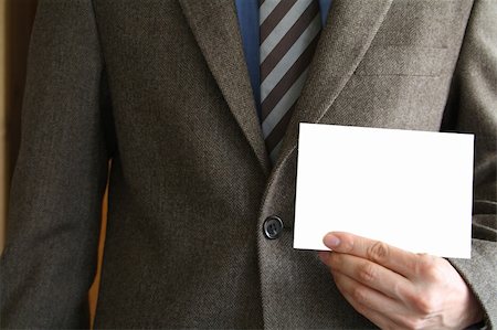 simsearch:400-04173629,k - Smartly dressed business man holding a white card (enter your own text). Stockbilder - Microstock & Abonnement, Bildnummer: 400-04451432