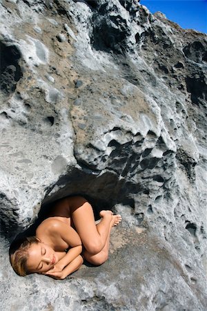 simsearch:400-04955255,k - Young Asian nude woman sleeping in a crevice in a rock. Stockbilder - Microstock & Abonnement, Bildnummer: 400-04451702