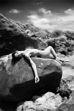 simsearch:400-04955255,k - Young adult Caucasian nude woman lying on rock with arm hanging down. Stockbilder - Microstock & Abonnement, Bildnummer: 400-04451748
