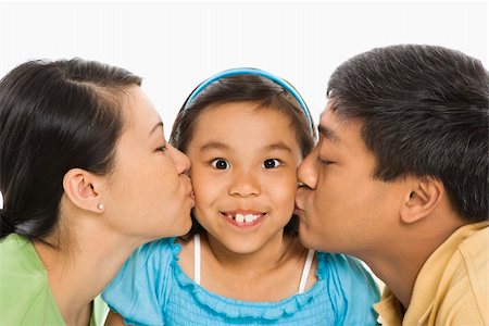 filipina mother daughter - Asian mother and father kissing opposite cheeks of smiling daughter in front of white background. Photographie de stock - Aubaine LD & Abonnement, Code: 400-04452252
