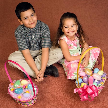 Hispanic brother and sister sitting on floor with Easter baskets looking up at viewer smiling. Photographie de stock - Aubaine LD & Abonnement, Code: 400-04452432