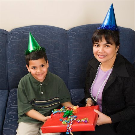 simsearch:400-04452450,k - Mother and son wearing party hats holding birthday presents smiling and looking at viewer. Stock Photo - Budget Royalty-Free & Subscription, Code: 400-04452446