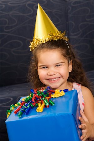 simsearch:400-04452450,k - Hispanic girl wearing party hat holding birthday present smiling and  looking at viewer. Stock Photo - Budget Royalty-Free & Subscription, Code: 400-04452441
