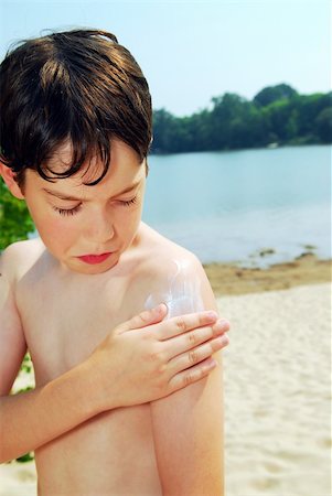 Young boy applying sunscreen on a beach Stock Photo - Budget Royalty-Free & Subscription, Code: 400-04453092